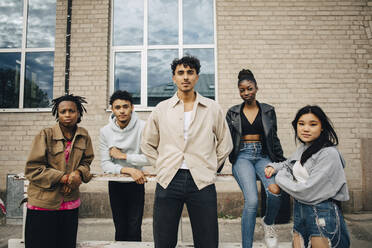 Portrait of confident multiracial young friends in front of wall - MASF31665