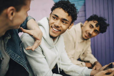 Smiling young man talking with friends - MASF31699