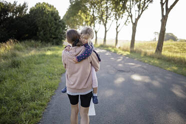 Mutter mit Tochter auf der Straße zwischen Bäumen - DWF00583