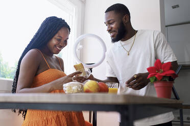 Man giving breakfast to pregnant woman at home - GGGF01200