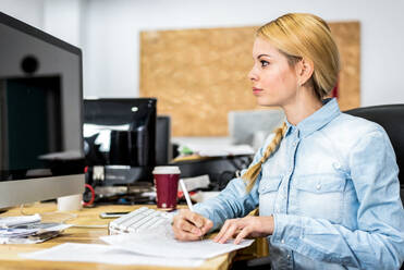 Positive female worker in formal wear browsing computer in light modern office - ADSF36495