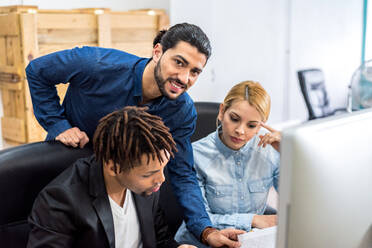 Group of optimistic multiracial coworkers in formal wear working with documents in modern light office - ADSF36497