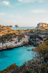 Atemberaubende Kulisse der massiven Felsenklippe über dem wellenförmigen, endlos blauen Meer an einem sonnigen Tag auf den Balearischen Inseln - ADSF36629