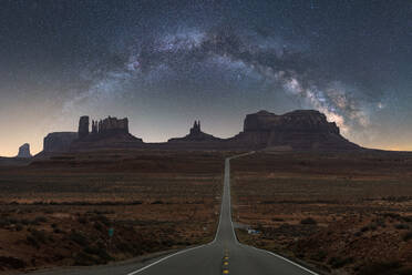 Atemberaubende Kulisse von Bergformationen mit Sternenhimmel zwischen Asphaltstraße in Monument Valley Navajo Tribal Park, Utah Arizona in USA - ADSF36822