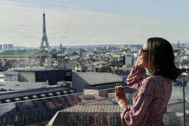 Tourist mit Blick auf den Eiffelturm vom Dach aus, Paris, Frankreich - KIJF04493