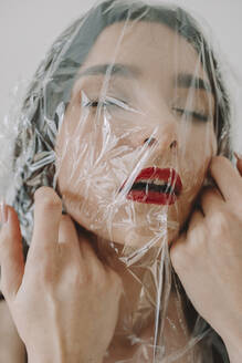 Gesicht einer Frau mit durchsichtigem Plastik bedeckt - ORF00033