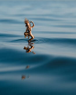 Bronzestatuette einer Hindu-Göttin, die auf den Wellen des sauberen blauen Wassers in der Natur tanzt - ADSF36901