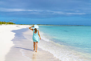 Beautiful woman walking on idyllic beach washed by Caribbean Sea, Barbuda, Antigua and Barbuda, West Indies, Caribbean, Central America - RHPLF22838