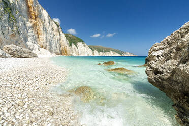 Die Wellen des türkisfarbenen, klaren Meeres umspülen die weißen Steine des Fteri Beach, Kefalonia, Ionische Inseln, Griechische Inseln, Griechenland, Europa - RHPLF22859