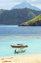 Strand der Insel Mahoro mit Ausflugsbooten und einem weit entfernten Vulkan auf Siau, Mahoro, Siau, Sangihe-Archipel, Nordsulawesi, Indonesien, Südostasien, Asien - RHPLF22981