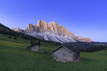 Sonnenaufgang über der Geislergruppe und den Berghütten im Frühling, Gampen Alm, Fünser Tal, Dolomiten, Südtirol, Italien, Europa - RHPLF23007