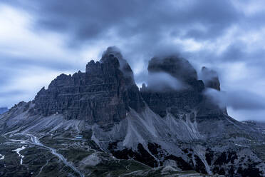Wolken in der Abenddämmerung am nebligen Himmel über den Drei-Zinnen-Gipfeln, Dolomiten, Südtirol, Italien, Europa - RHPLF23011