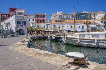 Blick auf bunte Cafés, Restaurants und Boote im Hafen vor blauem Himmel, Cales Fonts, Menorca, Balearen, Spanien, Mittelmeer, Europa - RHPLF23107