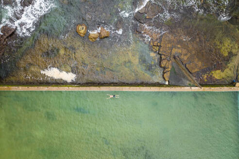 Luftaufnahme einer Person beim Schwimmen im Mona Vale Rockpool, Sydney, New South Wales, Australien. - AAEF15696