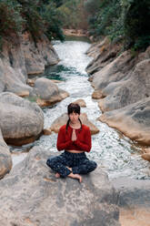 Entspannte Frau bei der Meditation im Fluss - ADSF37064