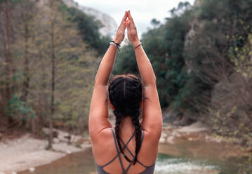 Rückenansicht anonyme Frau übt Yoga im Fluss - ADSF37066