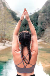 Rückenansicht anonyme Frau übt Yoga im Fluss - ADSF37068