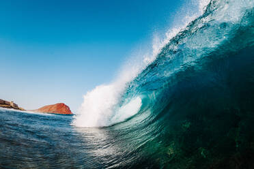 Powerful foamy sea waves rolling and splashing over water surface against cloudy blue sky - ADSF37305