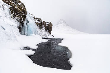 See im verschneiten Hochland unter bewölktem Himmel in Island - ADSF37386