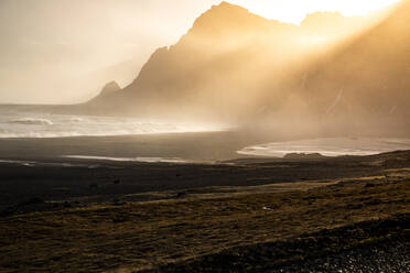 Berühmter ungewöhnlicher schwarzer Sandstrand und felsige Küstenlinie bei Sonnenuntergang in Island - ADSF37412