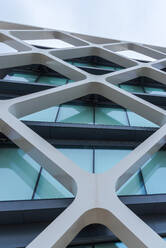 Von unten Exterieur des modernen Gebäudes mit Fenster und weißen dekorativen geometrischen Elementen auf der Straße der Stadt gelegen - ADSF37468