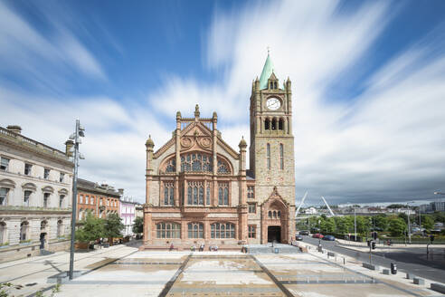 Guildhall with clock tower in city under cloudy sky - FCF02071