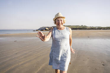 Glückliche ältere Frau tanzt und hat Spaß am Strand - UUF27204
