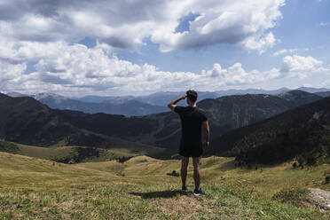 Hiker looking at mountains on sunny day - PNAF04509