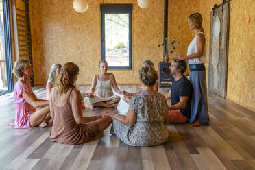 Group of friends practicing meditation together in yoga class - DLTSF03086