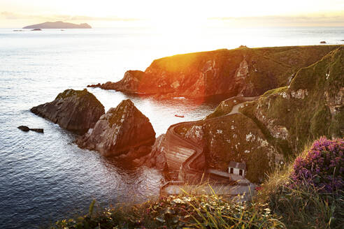 Irland, Grafschaft Kerry, Blick auf den Hafen von Dunquin und die umliegenden Klippen bei Sonnenuntergang - FCF02095