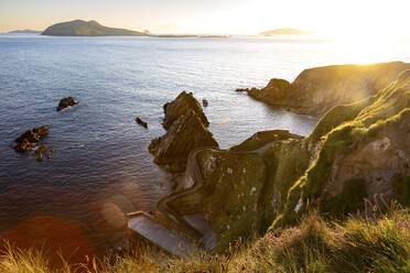 Irland, Grafschaft Kerry, Blick auf den Hafen von Dunquin und die umliegenden Klippen bei Sonnenuntergang - FCF02096