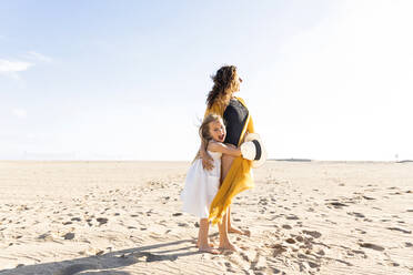 Ältere Frau mit Tochter steht am Strand an einem sonnigen Tag - MEGF00061