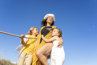 Glückliche reife Frau mit Sohn und Tochter unter blauem Himmel stehend - MEGF00067