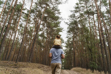 Älterer Mann trägt Mädchen auf den Schultern und wandert im Wald - TOF00103