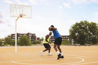 Son and father playing at basketball court - JCCMF07175