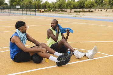 Vater und Sohn machen Pause auf dem Basketballplatz - JCCMF07188