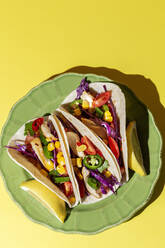 Hausgemachte mexikanische Tacos mit frischem Gemüse und Huhn mit starkem Licht auf gelbem Hintergrund. Gesundes Essen. Typisch mexikanisch - ADSF37532