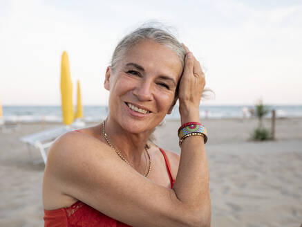 Glückliche ältere Frau mit grauem Haar am Strand - FLLF00677