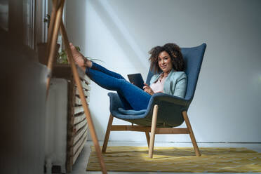 Selbstbewusste Geschäftsfrau mit Tablet-PC auf einem Stuhl sitzend - JOSEF13012