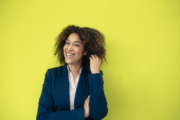 Cheerful businesswoman in front of green wall - JOSEF13099