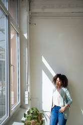 Geschäftsfrau schaut durch ein Fenster im Büro - JOSEF13184