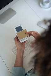 Geschäftsfrau macht Zahlung durch Kreditkarte am Schreibtisch im Büro - JOSEF13189