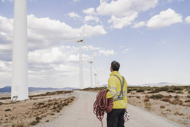 Ingenieur mit Seil bei der Betrachtung von Turbinen im Windpark - EBBF06302