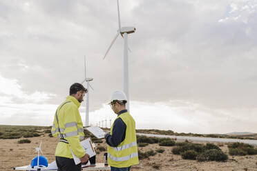 Engineer discussing with colleague at wind farm - EBBF06315