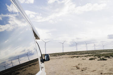 Reflexion von Windturbinen auf dem Glas eines Lieferwagens auf einem Bauernhof - EBBF06346