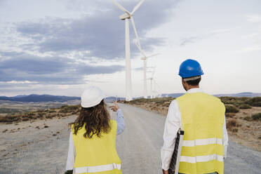 Engineer discussing with colleague at wind farm - EBBF06361