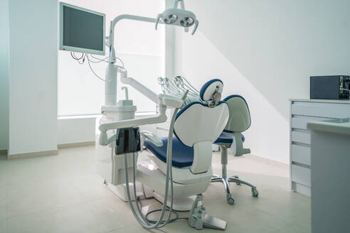 Moderner Zahnarztstuhl mit Monitor und Instrumenten in einem hellen Büro in einer Klinik - ADSF37763