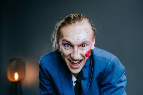 Fröhlicher junger Mann mit Clown-Make-up im Gesicht - YTF00023