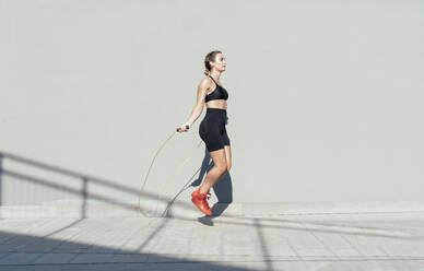 Young athlete skipping rope on sunny day - OIPF02367