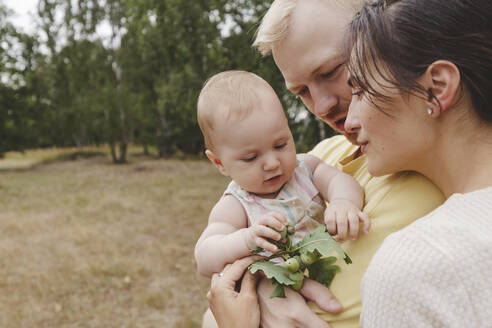 Mutter und Vater spielen mit ihrer Tochter im Park - IHF01208